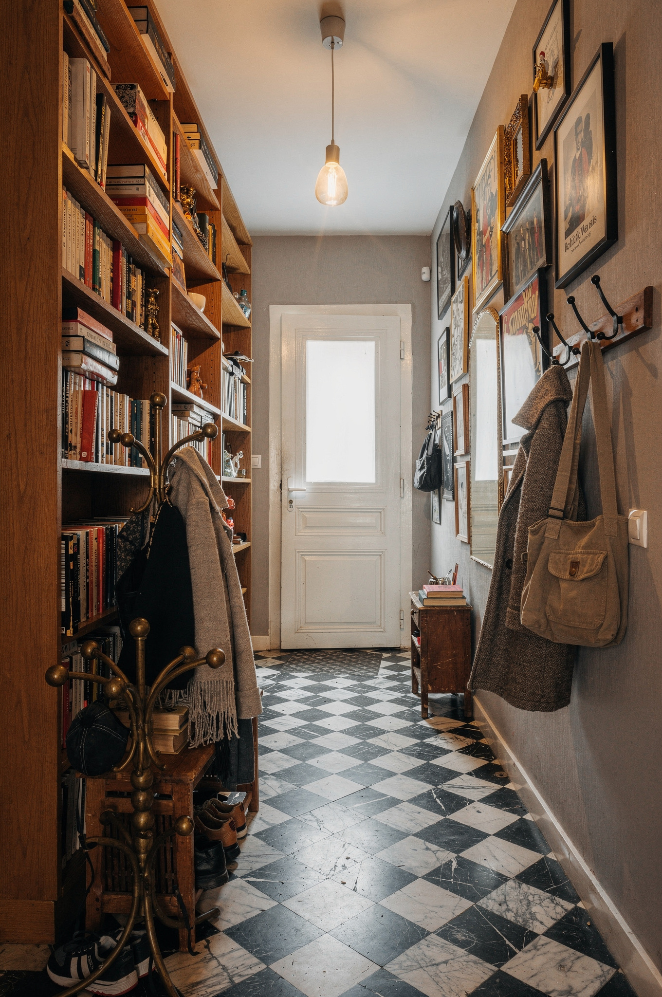 A terracotta and cream checkerboard tiled floor in a bright kitchen with warm wood units