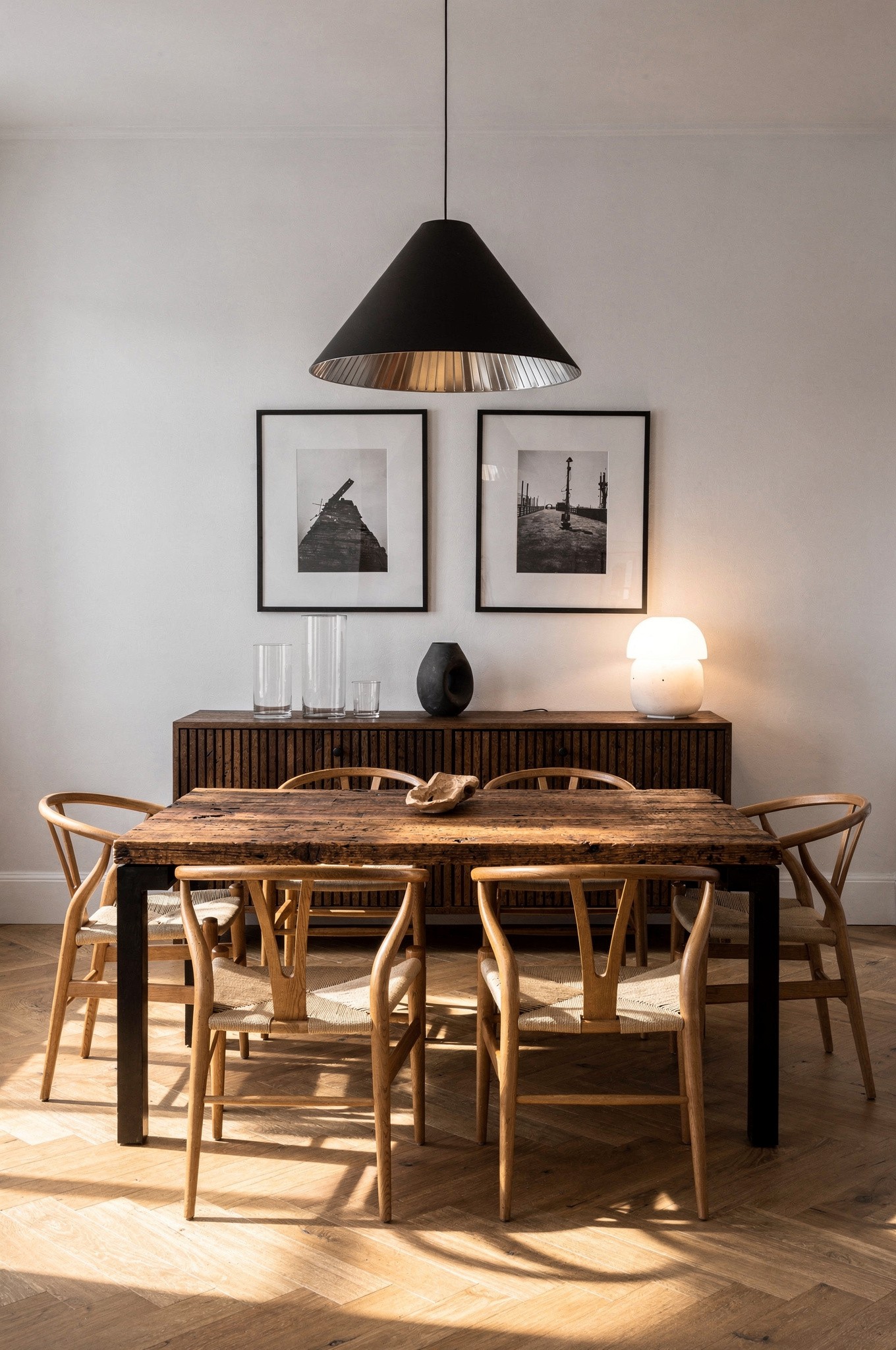 A living room with a walnut sideboard, oak dining table and light pine shelving working together harmoniously